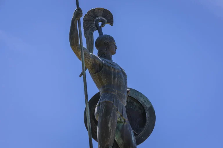 Achilleion Palace statue in Corfu against a clear blue sky
